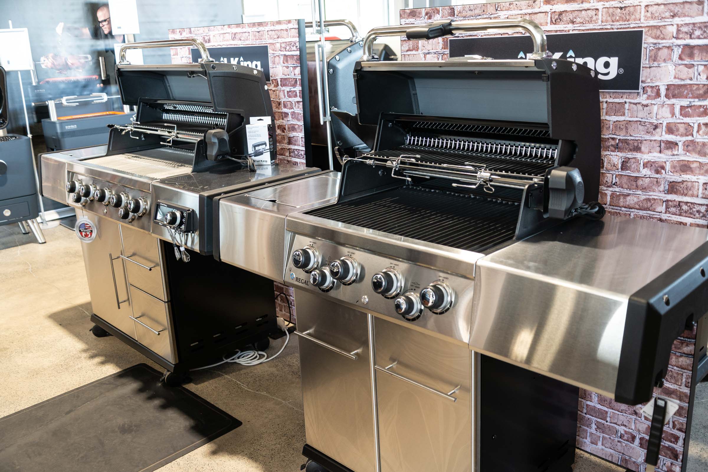 Nahaufnahme zweier Broil-King-Gasgrills mit geöffneten Deckeln