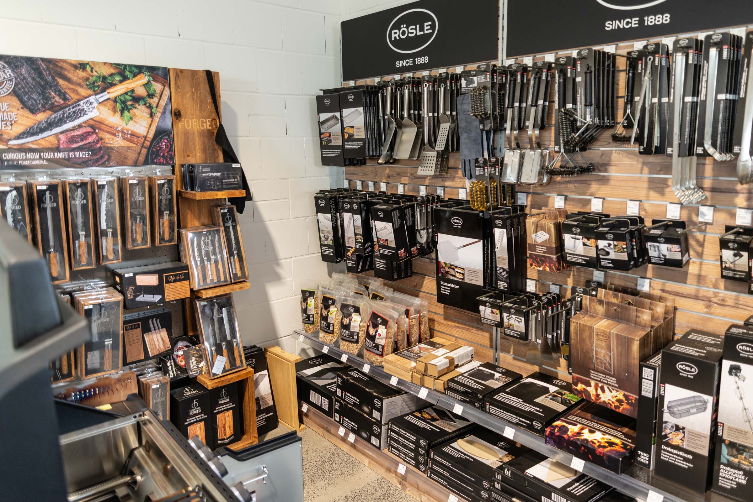 Zubehörwand im GREENOL BBQ Store mit Grillbesteck, Messern und Grillzubehör
